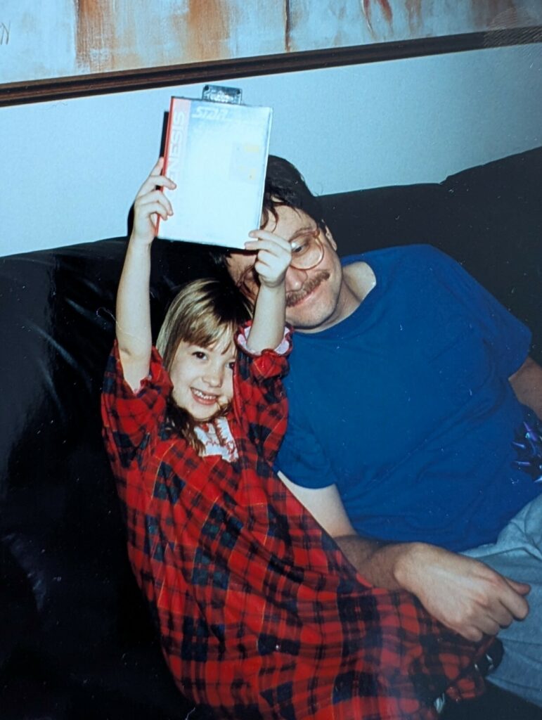 old picture of a small child holding up a Sega video game. 